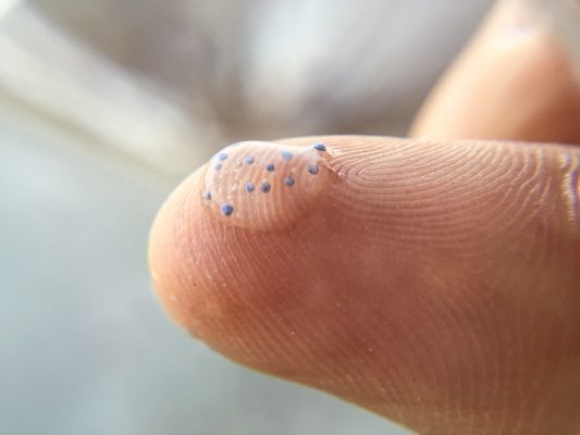 microbeads on finger