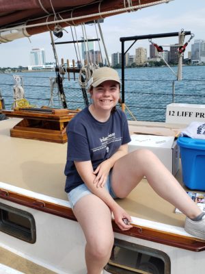 young woman on ship with Windsor Canada skyline in background